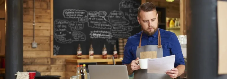 Barista reading paper in coffee shop