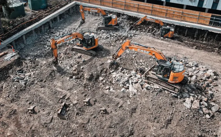 Excavators digging at a rocky construction site.