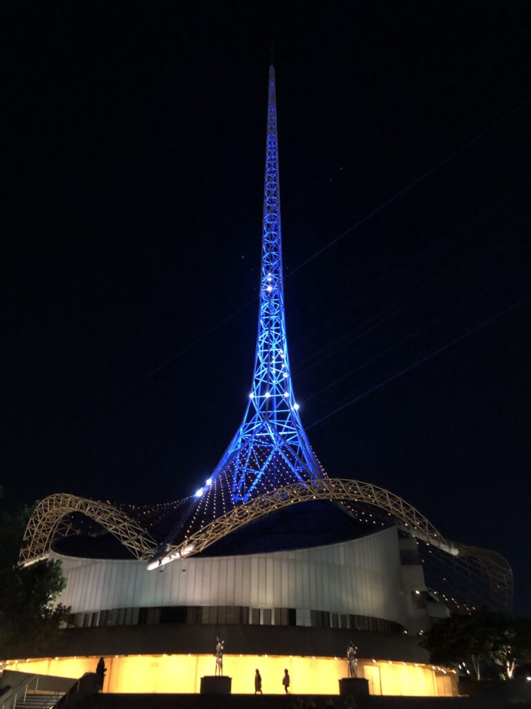 Illuminated spire at night, dramatic architecture.