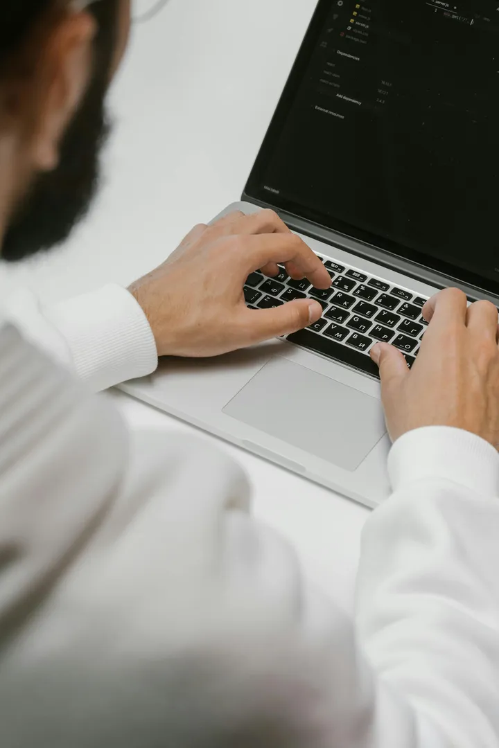 Person typing on laptop keyboard, close-up view.