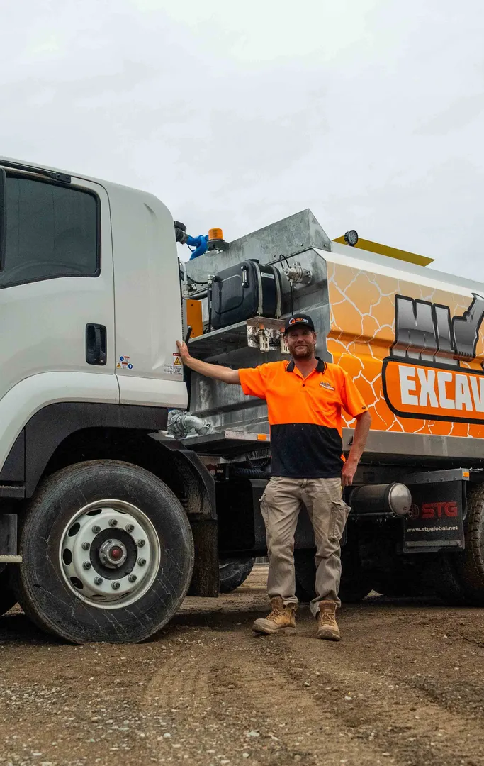 Worker standing beside an excavation truck