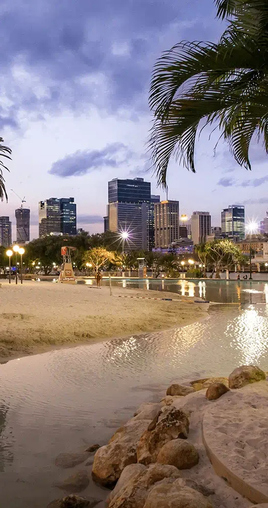 Beachfront cityscape at twilight with palm trees
